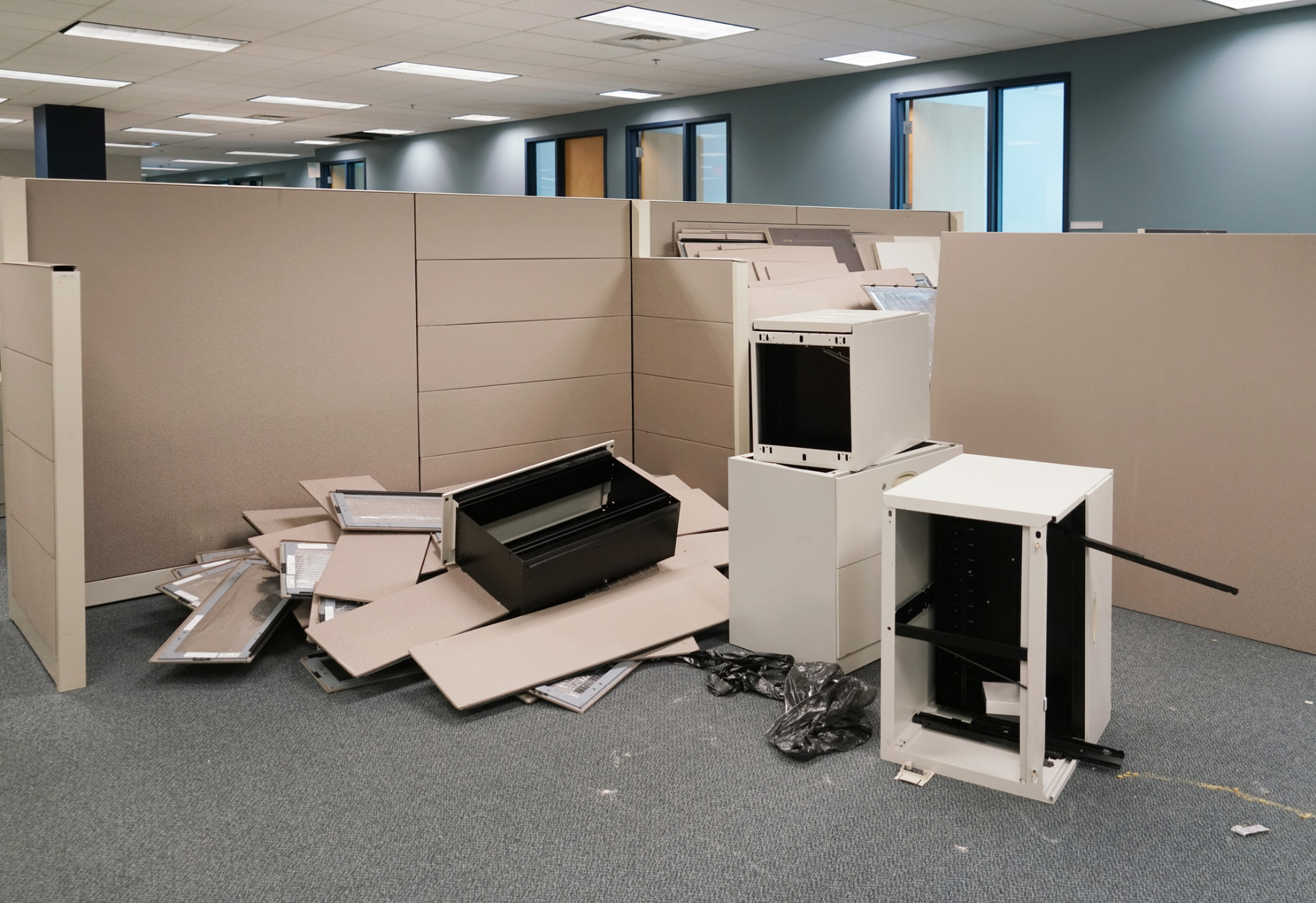Office cubicle panels, filing cabinets, and equipment piled up during an office cleanout