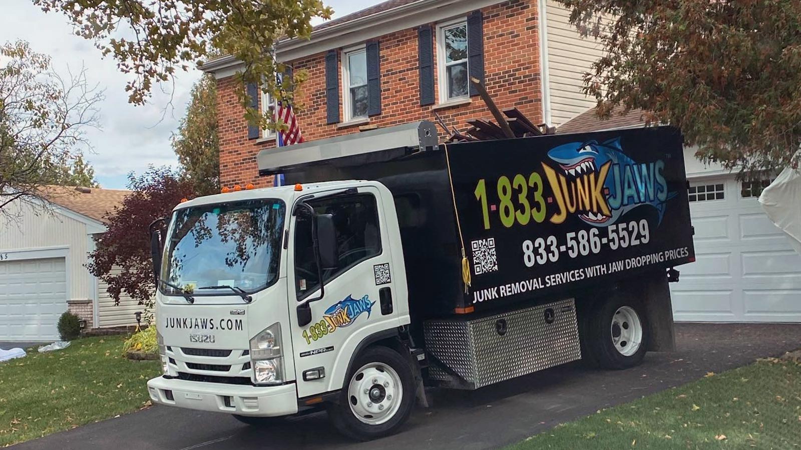 A Junk Jaws truck sits in a driveway of a home they are working at.