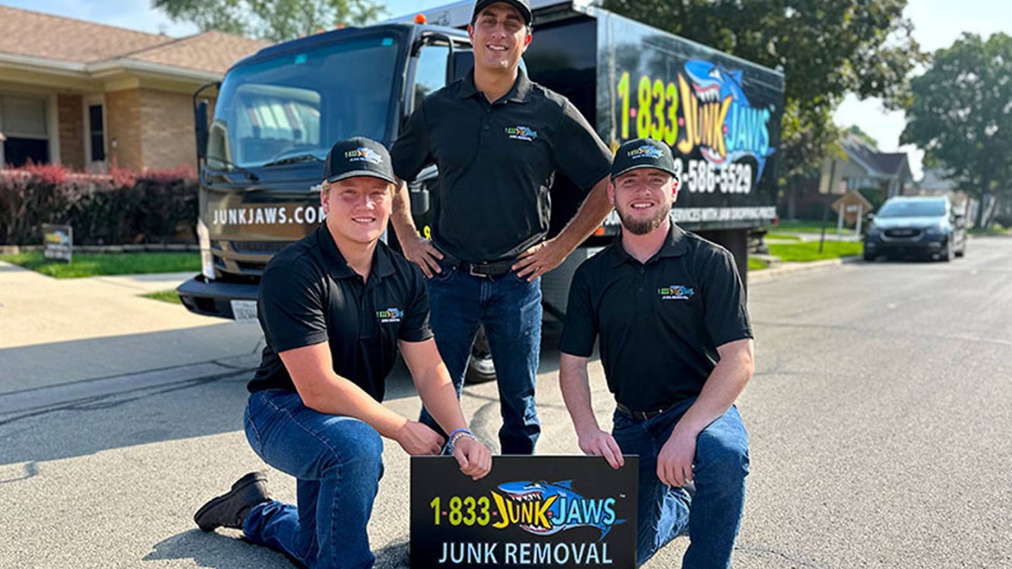 Three Junk Jaws employees pose in front of their truck.