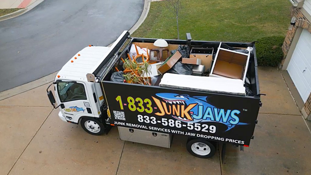 A fully loaded Junk Jaws truck in a driveway.