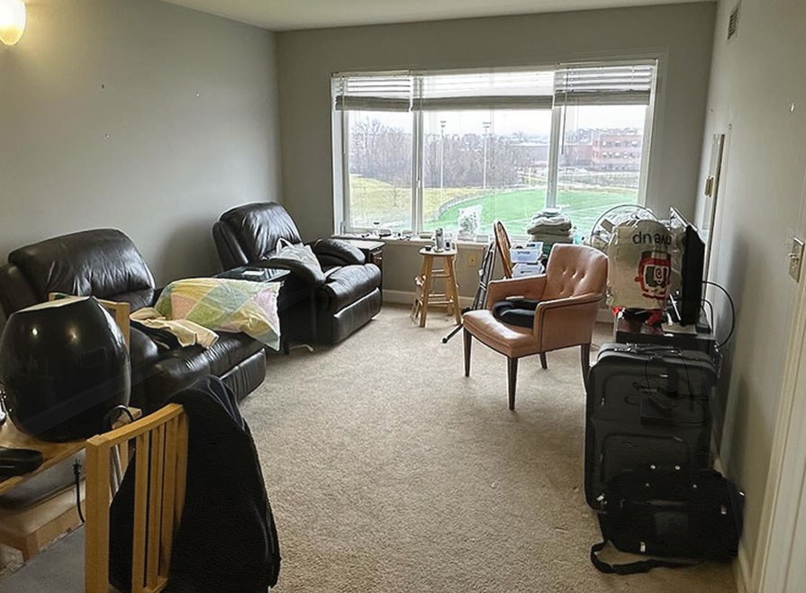 A Chicago living room cluttered with an old couch and unwanted furniture before pickup.