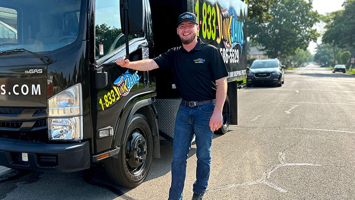 A Junk Jaws employee poses in front of his truck.