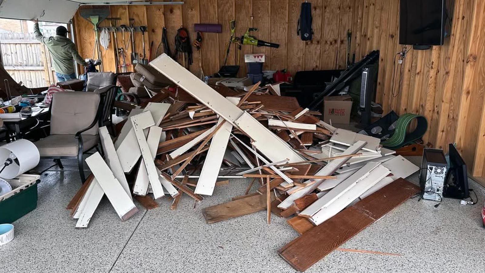A messy pile of demolition debris sits behind a home.