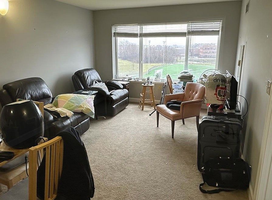 A living room packed with leather recliners and chairs before Junk Jaws furniture removal.