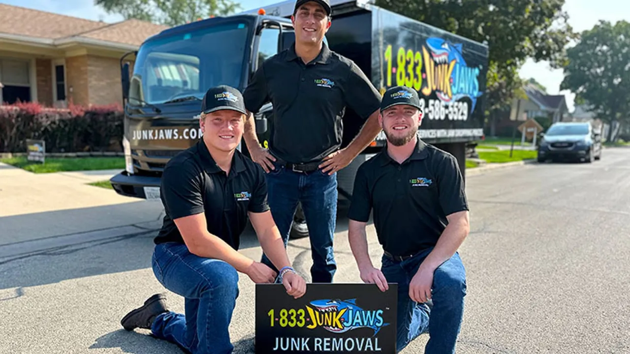 Three Junk Jaws employees pose in front of their truck.