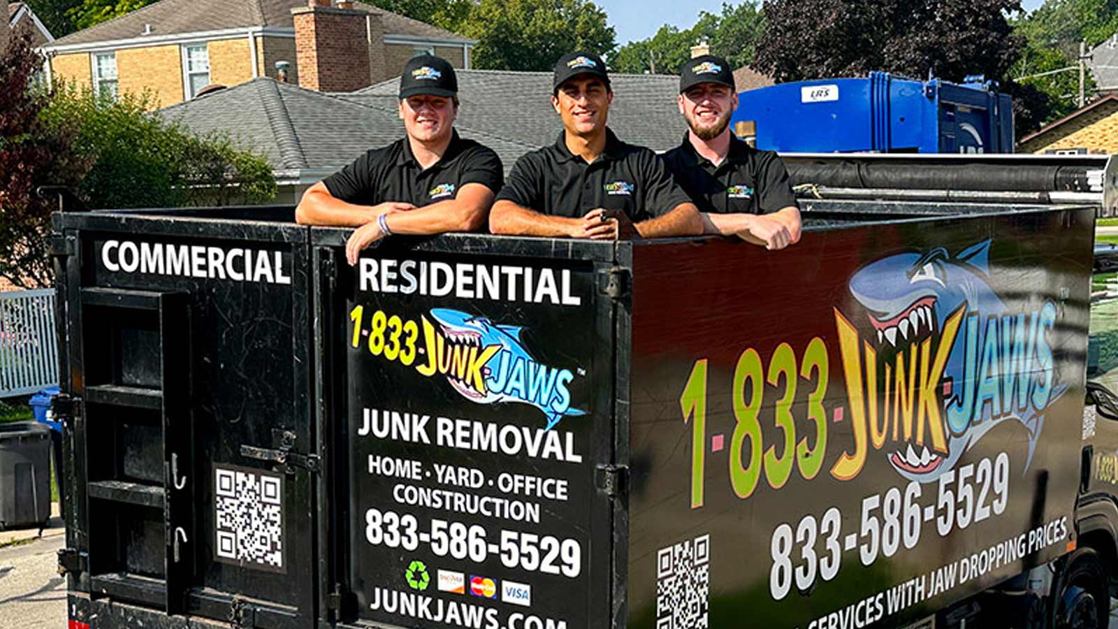 Three Junk Jaws employees pose in the bed of their truck.