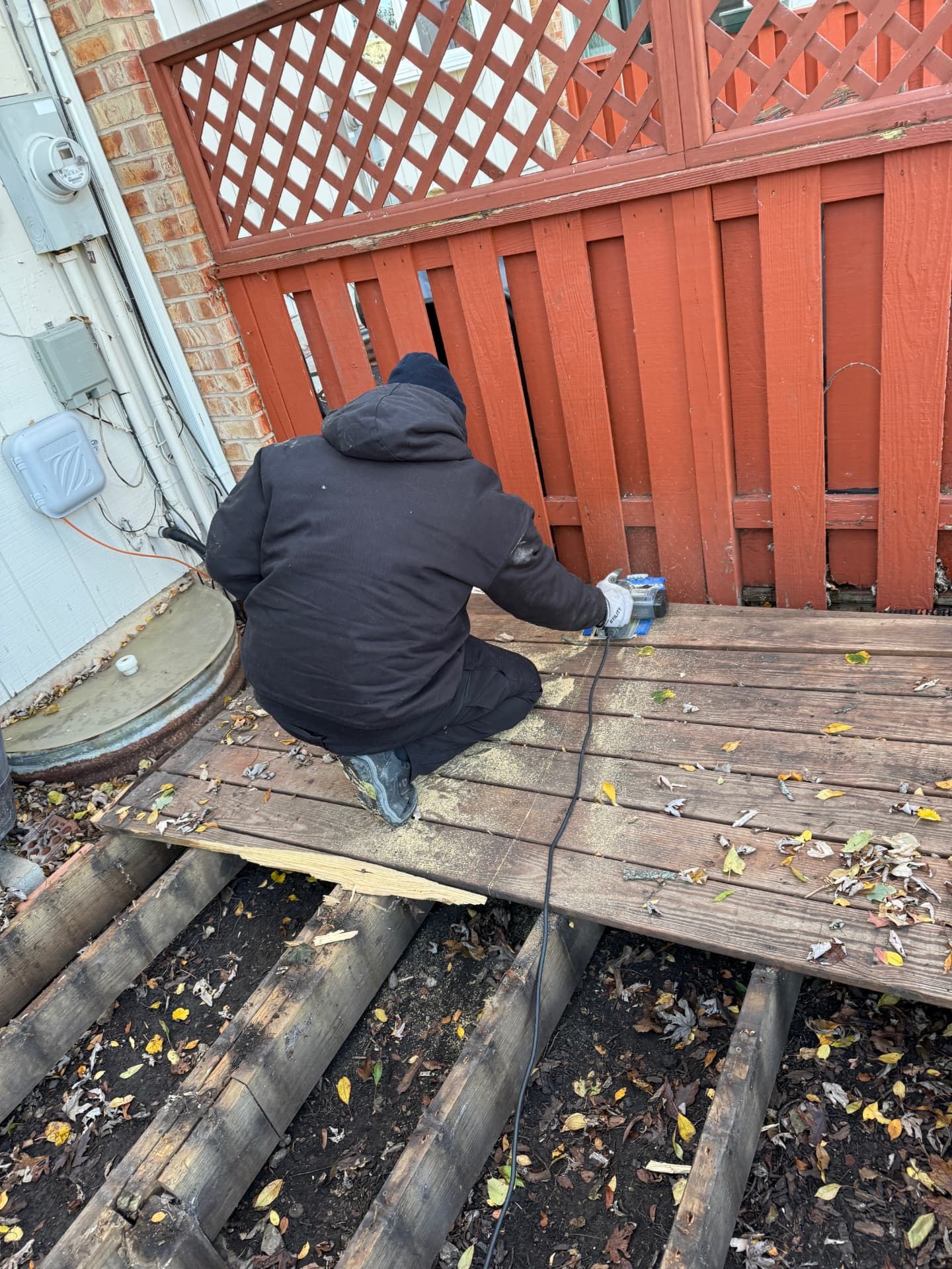 A Junk Jaws crew member cutting apart old deck boards during a Chicago deck removal.