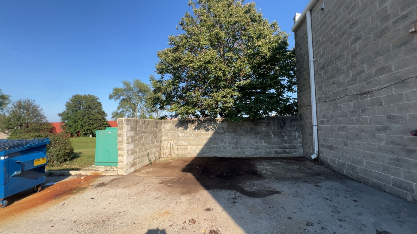 The same dumpster enclosure area completely cleared after Junk Jaws hauled the overflow away.