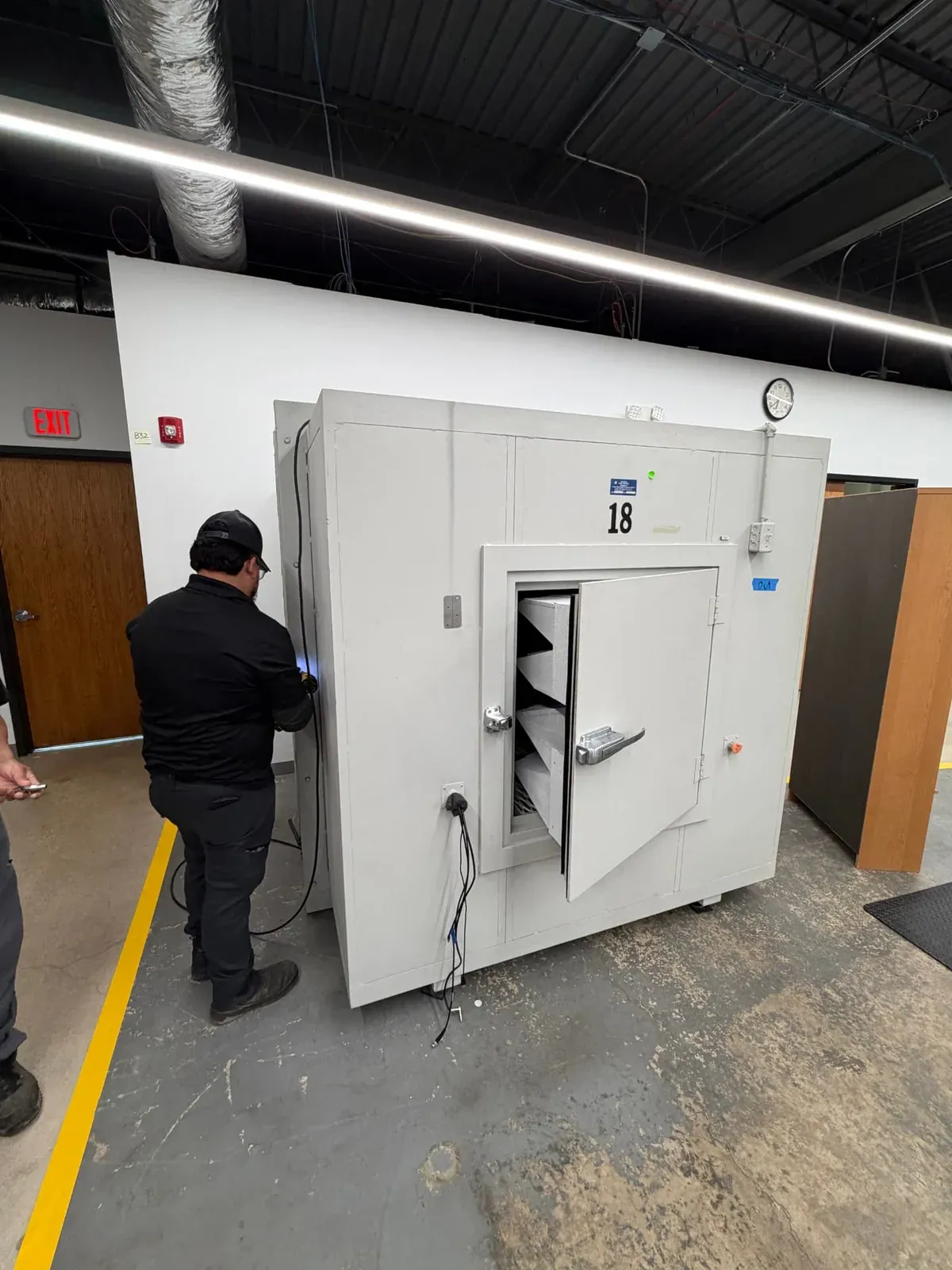 A Junk Jaws technician working beside a large modular office booth inside a commercial space.